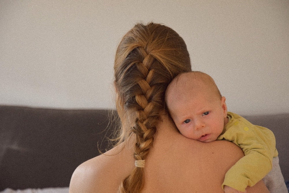 Neugeborenes an der Schulter der Mutter